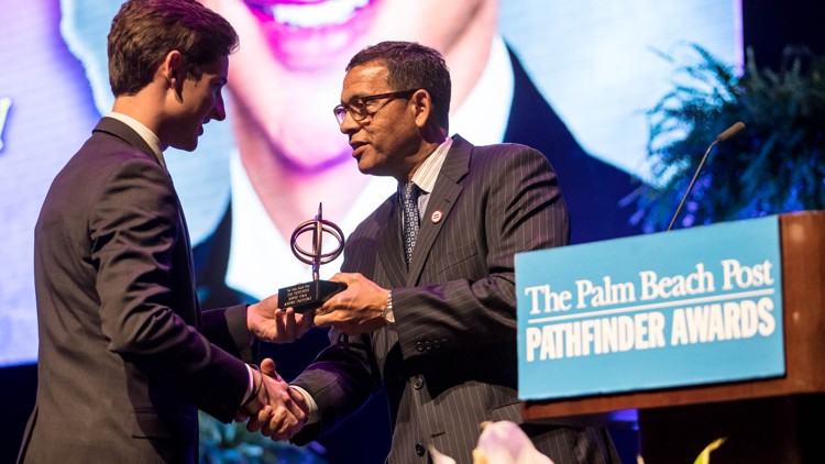 Robert Linck of Oxbridge Academy accepts the $4,000 scholarship for Academic Excellence from Patrick Franklin at the 35th annual Pathfinder Scholarship Awards. (Allen Eyestone / The Palm Beach Post)